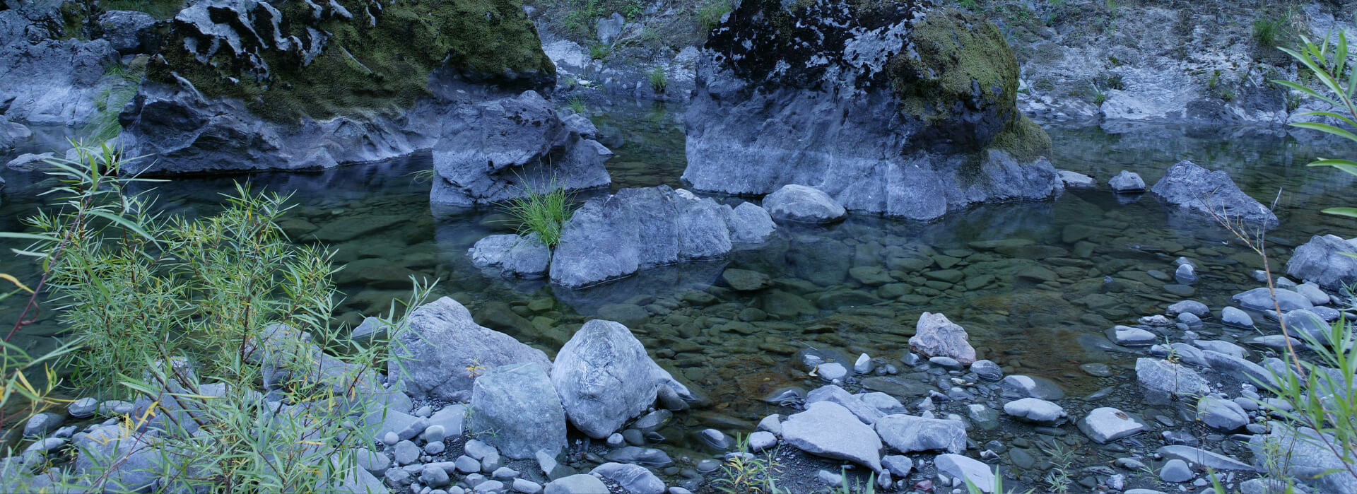 Rocks and moss covered boulders in riverbed in remote Trinity Mountain wilderness, California.