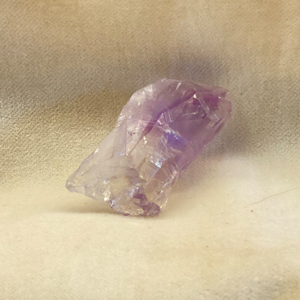 Amethyst Crystal Point. Clear to purple coloring. Naturally occurring, unaltered shape and structure. Piece pictured is approx. 1.5 inches long.