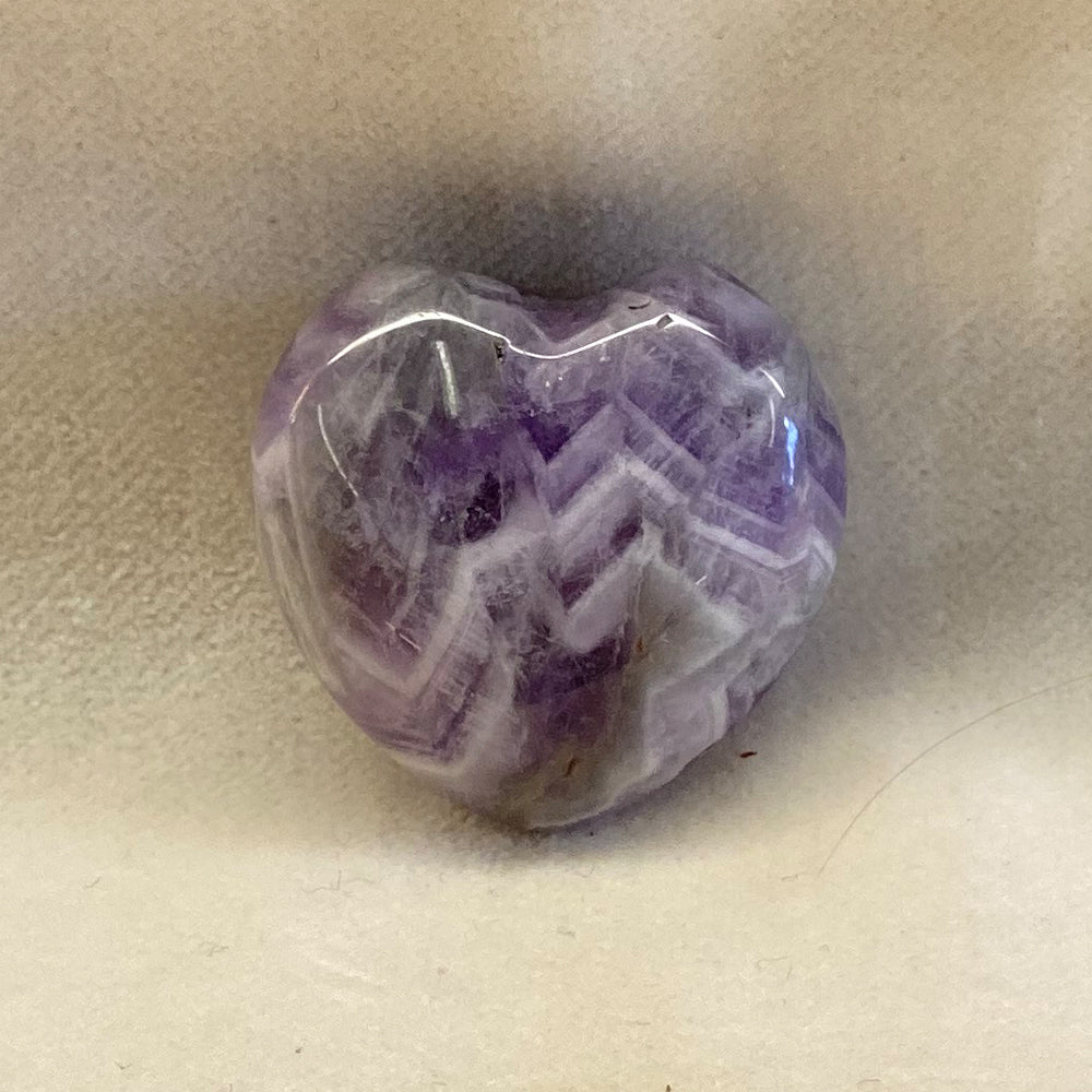 Handcrafted Chevron Amethyst Heart. Purple Amethyst banded with White Quartz. Smooth surface. These are high quality with super patterns.Size: approx. 1 1/4 inch. Chevron Amethyst is said by the ancients to be a stone of Peace, Love and Calmness.
