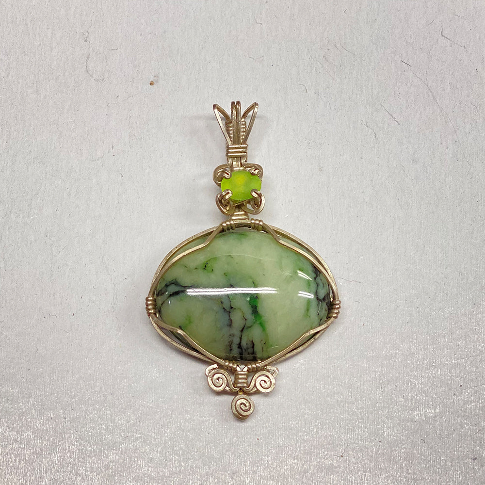 Peridot and RiverBlossom Jade Pendant. Beautifully patterned jade pendant with peridot gemstone. Intricate sterling silver wire wrapping. 2.5 x1.5 inches.
