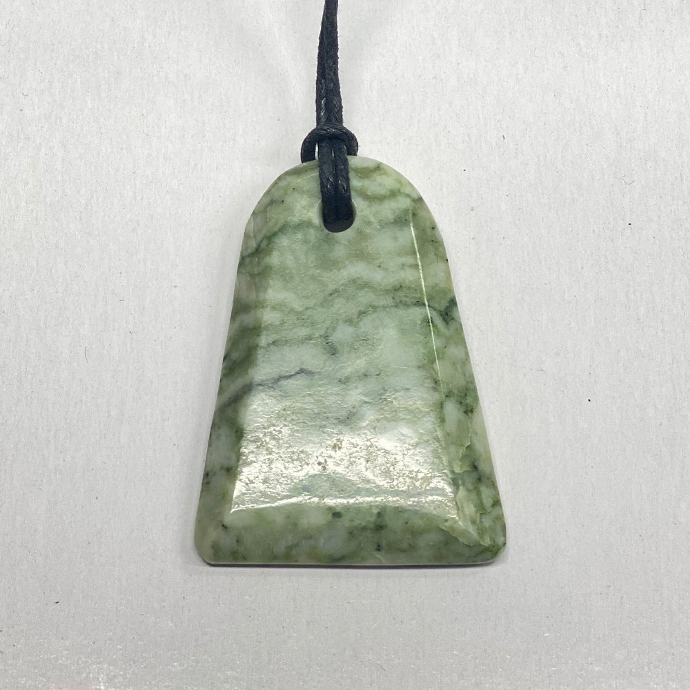 RiverBlossom Jade Adze Pendant. Smooth, top quality craftsmanship defines this ancient shape. The Jade used in this piece was sourced from our helicopter trips to our private property in the Trinity Alps area in California. We call this "RiverBlossom Jade," as the winter storms create high water that delivers the jade for us to simply pick up as the water recedes in the summer.