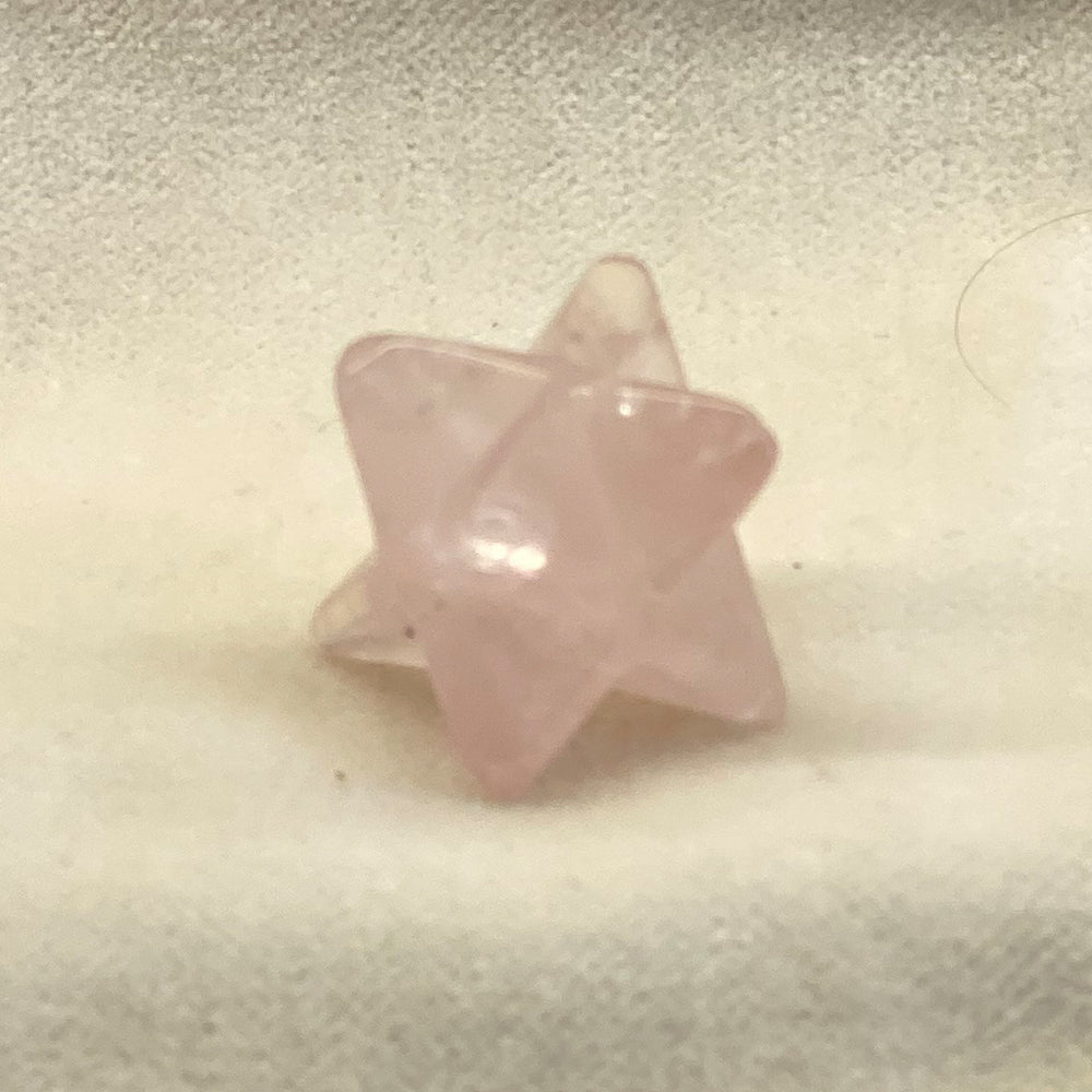 Handcrafted Rose Quartz Merkabah. A powerful ancient sacred geometry shape in a pleasing rosy pink color. Size: approx. 3/4 inch. The Merkabah is a star tetrahedron. The 2 intersecting pyramids are said to balance your inner powers and attract immense energy to help with your current needs.
