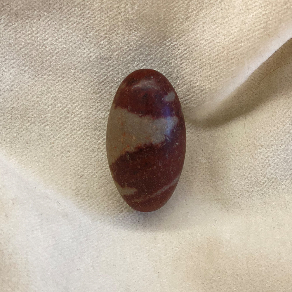 Shiva Lingam. This is the stone type from the movie "Romancing the Stone." Sourced and shaped by native people from the Narmada River in India. They say the stone promotes closeness as well as fertility. Size: approx. 1.25 inches.