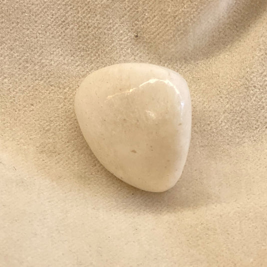 Tumble Polished Scolecite.  An uncommon mineral with unique images in the surface.  This is a small tumbled, polished stone about 1 inch in size.  Milky white with occasional light brown streaks & accents.   Silky smooth surface.  Ancients carried this stone for protection and for a calming effect.
