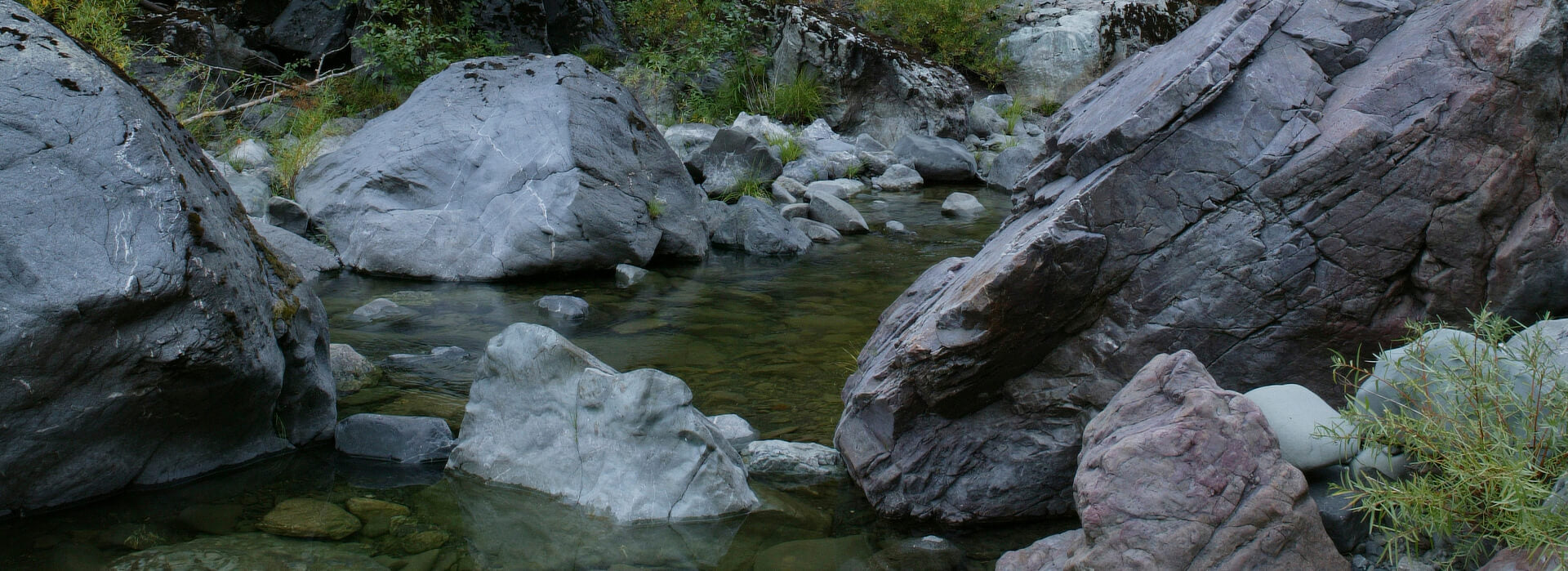 Colored rocks and boulders in river gorge, Trinity Mountain wilderness, California.
