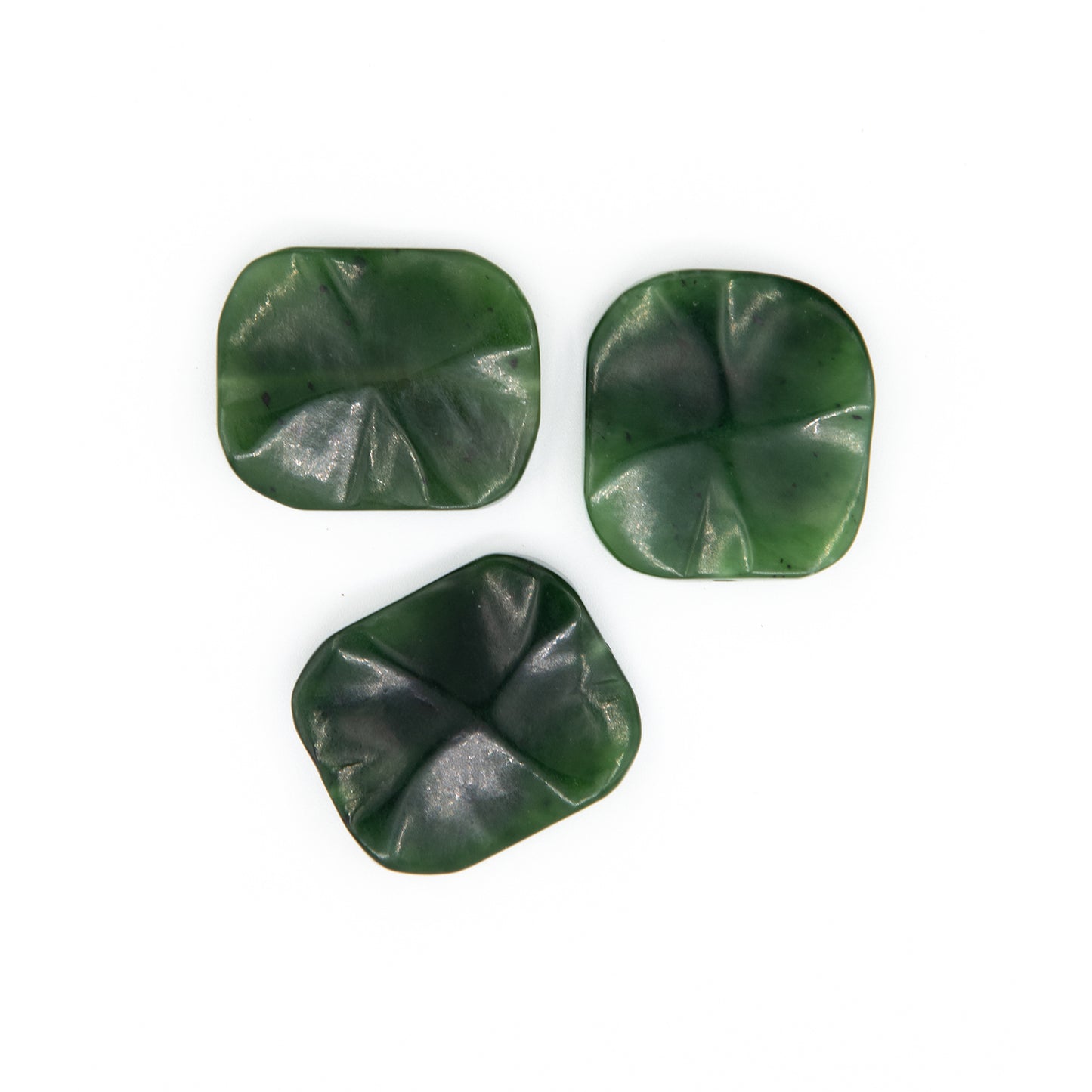 Unique Canada Jade Beads.  A unique design in green translucent Jade sourced in British Columbia.  These beads have a beautiful undulating shape with a pattern carved into the face on both sides.  Jade is said to bring prosperity and good health.  Size: over 1 inch on each side.