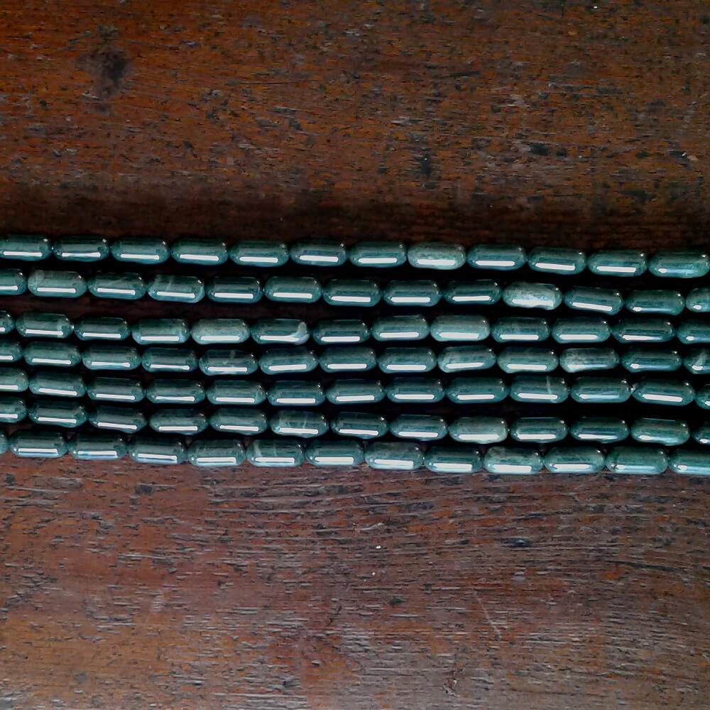 Exquisite California Jadeite beads.  Gun Blue Green color with White crystalline accents.  Tic tac shaped beads are over 1/2" long x 1/4" diameter.  Strands are 16" in length.  Artisan quality.  