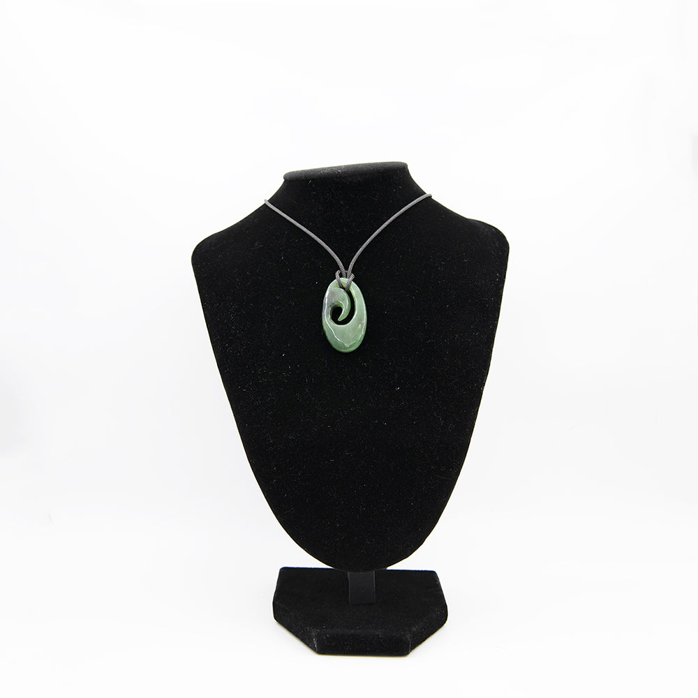 Maori Style Jade Pendant.  Canadian Jade finely carved in New Zealand Maori style.  Translucent greens with some black areas.  One of a kind piece.  1 1/2 inches by 7/8 inch