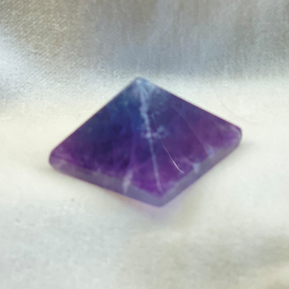 Handcrafted Fluorite Pyramid. Choice Fluorite! Very nicely made and polished powerful pyramids. May be multicolored. Fluorite changes color in a blacklight. Size: 1 inch.