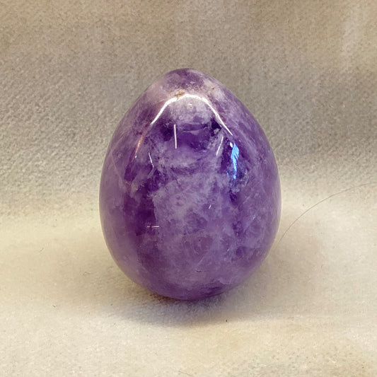 Handcrafted Amethyst Egg.  Variegated purple color.  Smooth, polished surface is superb.  Vivid color.  Size: approx. 1.25 inches.