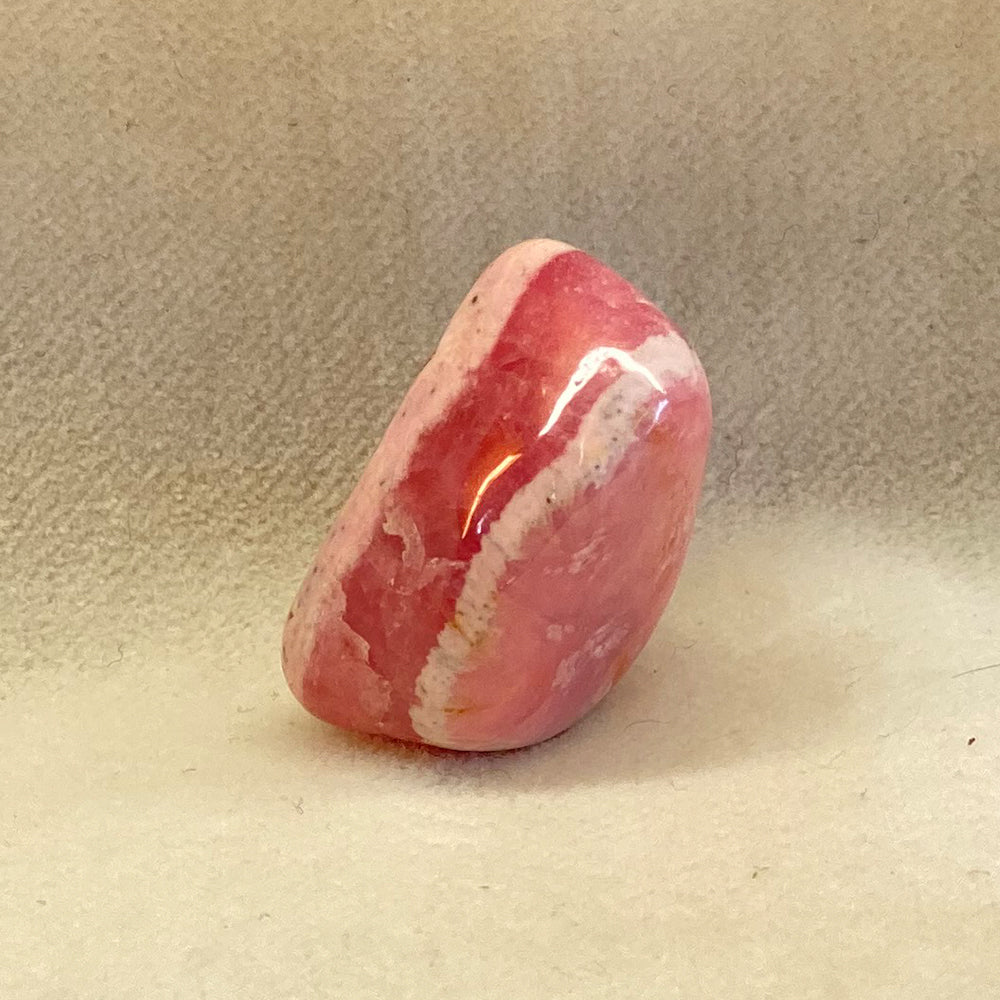 Rhodochrosite Stones from Argentina.  Banded shades of pink and white.  Tumbled, smooth.  Each stone has unique shape and pattern.  Stone size 1 inch.  Really nice quality and hard to find. Mystics call Rhodochrosite the stone of Love.