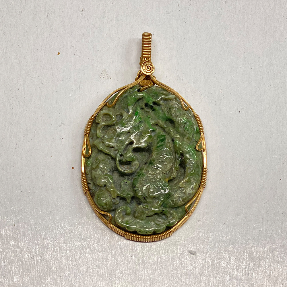 Carved RiverBlossom Jade Dragon Pendant.  A good friend from China took a few of our RiverBlossom Jade raw pieces and had these machine carved.   We then had this expertly wire wrapped with heavy gold filled wire.  The jade used in this piece was sourced from our helicopter trips to our private property in the Trinity Alps area in California.  The jade portion of the pendant is 2 inches high by 1.5 inches wide.
