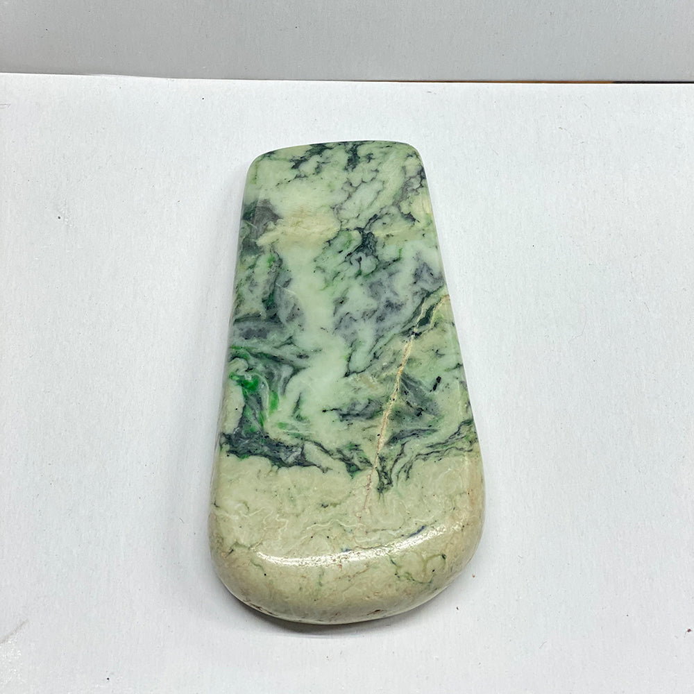 RiverBlossom Jade Stylized Adze.  A gorgeous pattern in this Jade display piece.  Lots of color play and swirling patterns in this ancient shape.  A couple of natural void lines are polished smooth.  This is carved as a decorative piece in the mode of a tool.  One of a kind.