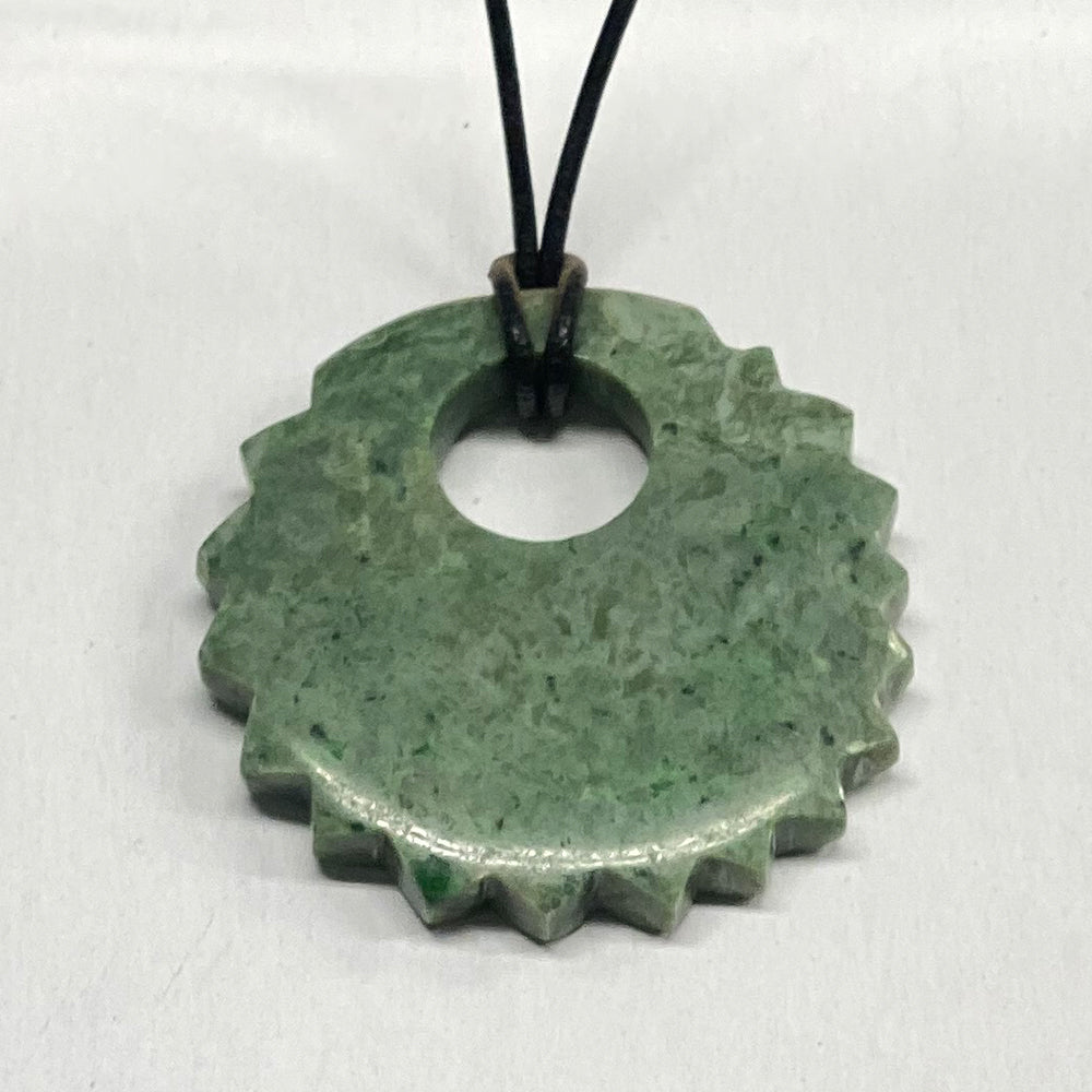 Mendocino California Jade Sun Pendant.  Carved and sourced here in Mendocino CA, this unique shape is very pleasing to the eye.   The green color is quite deep.  The jade used in this piece was sourced from our helicopter trips to our mining claims in the Leech Lake mountain area in Mendocino County, California.