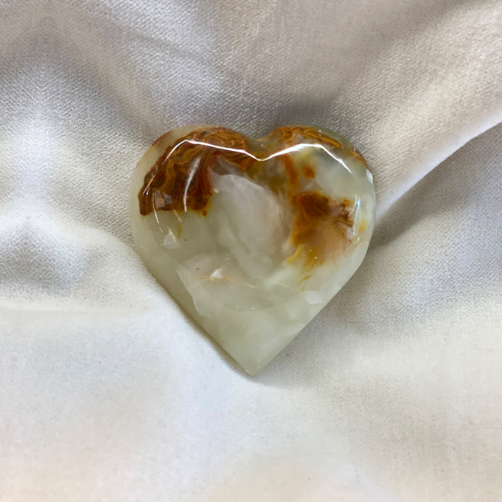 Hand Carved Onyx Heart.  Unique patterns and colors in these. Sizes vary but are around 2+ inches.Folklore has it that onyx is a stone of positivity and healing.