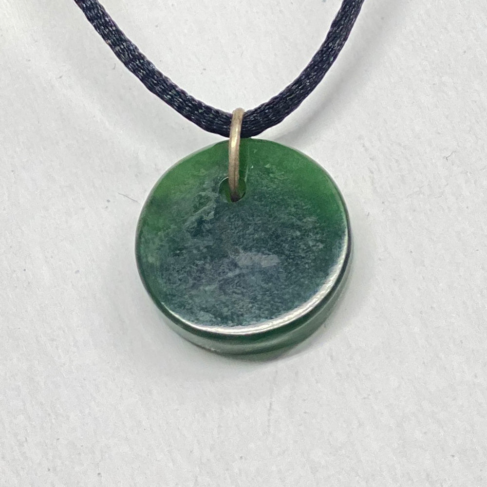 Small Green Jade Disc Pendant.  A pleasing small pendant with nice Jade and simple shape.  Jade sourced at Dease Lake, British Columbia.  Very cohesive stone with smooth finish.